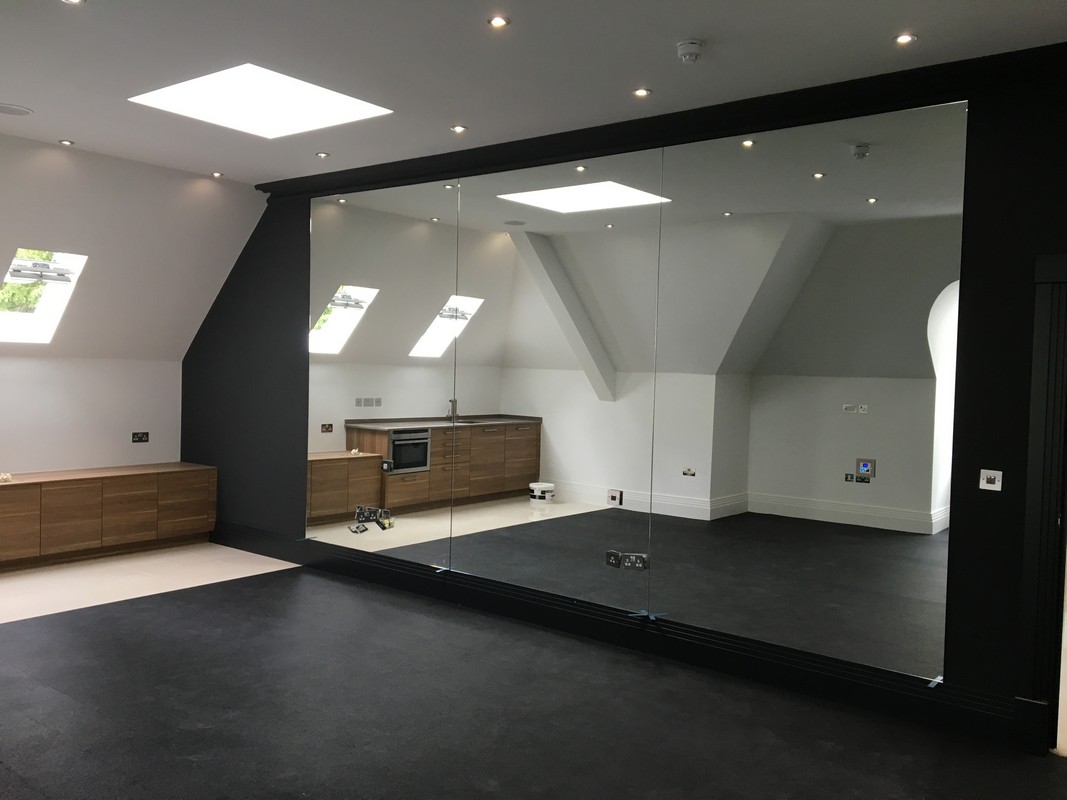 Frameless glass wall dividing loft conversion in Earl's Court